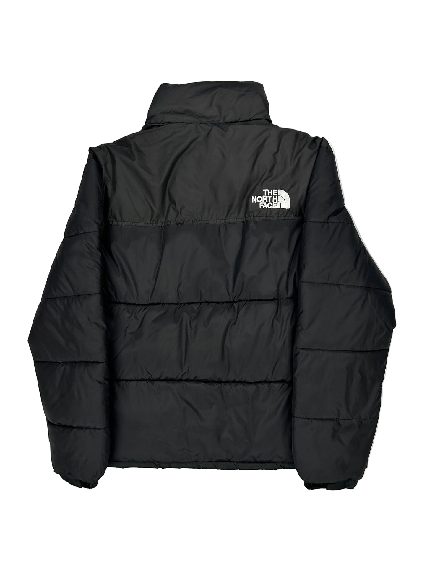 Folded black puffer jacket with a brand logo on a light gray background Folded black puffer jacket with a brand logo on a light gray background