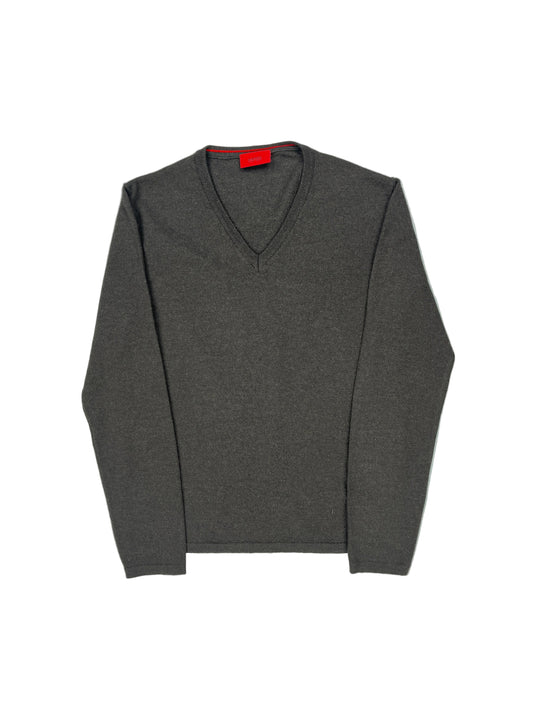 Folded gray sweater with a red tag on a white background