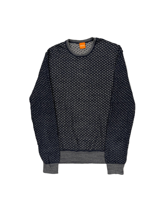 Black patterned sweater with an orange tag on a white background
