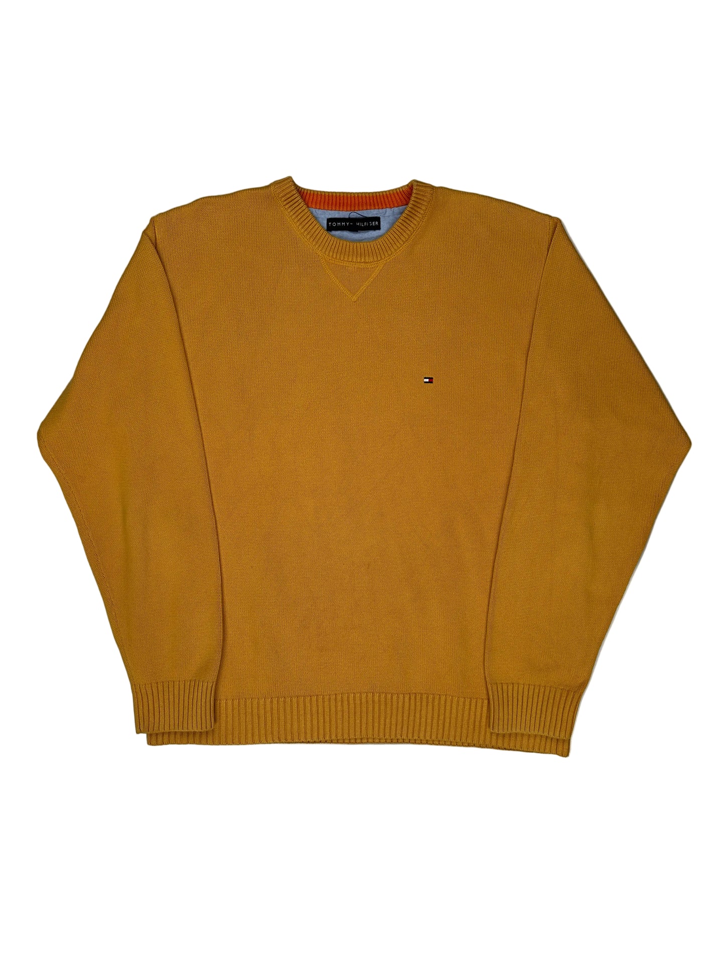 Mustard yellow sweater on a white surface