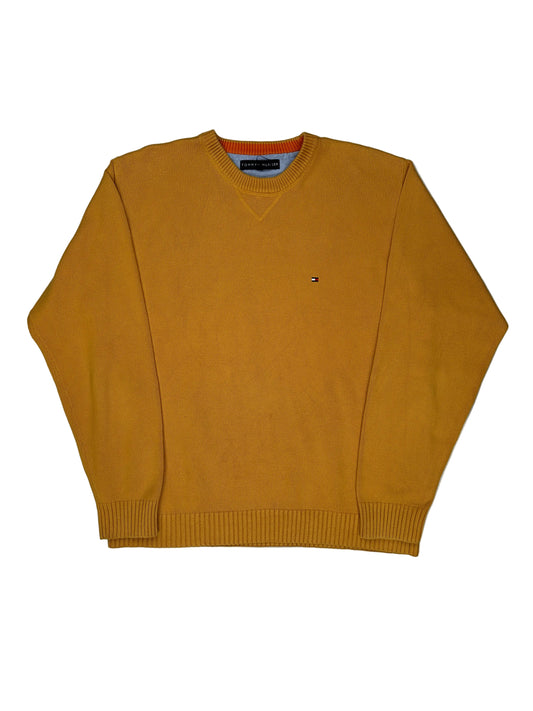 Mustard yellow sweater on a white surface