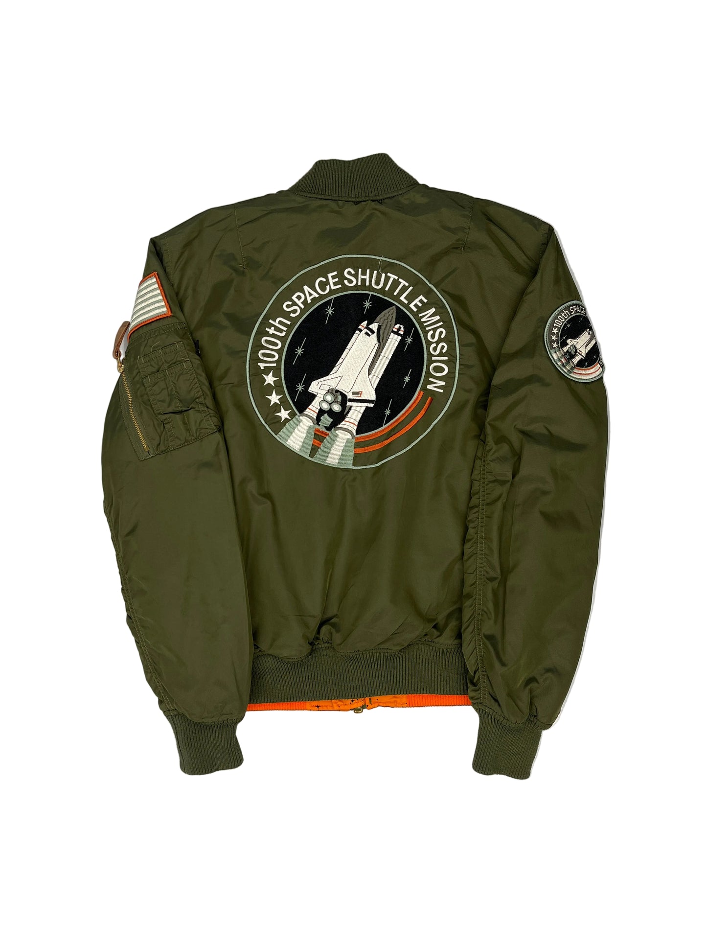 Green jacket with space shuttle mission patch on a white background